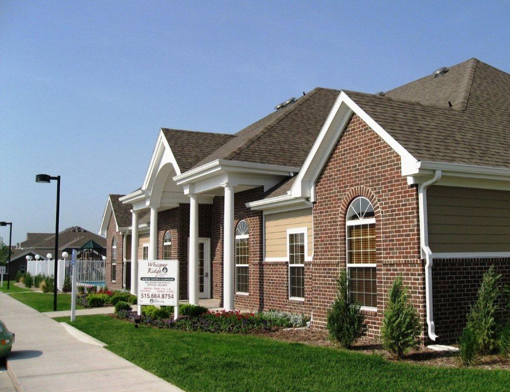 A brick house with a sign in front of it.