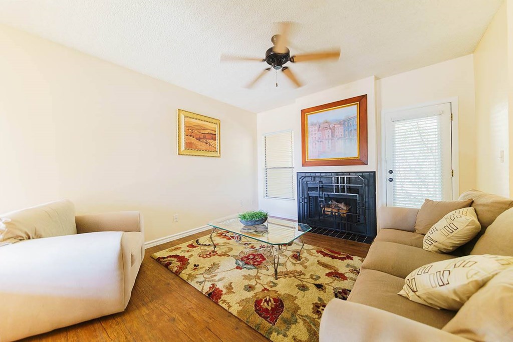 A living room with a fireplace and a rug.
