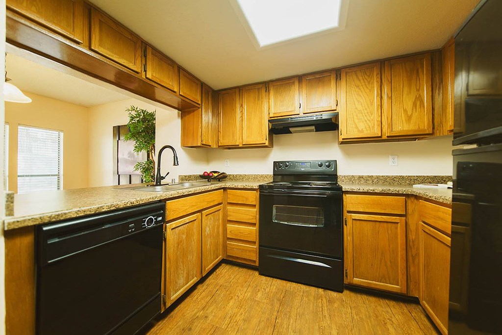 A kitchen with wooden cabinets and black appliances.