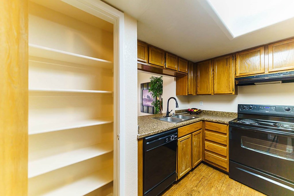 A kitchen with black appliances and wooden cabinets.