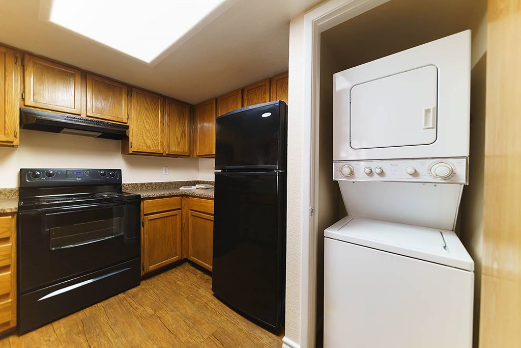A black oven sits next to a black microwave in a kitchen.