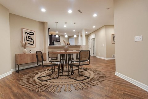 A modern dining room with a wooden table and chairs.