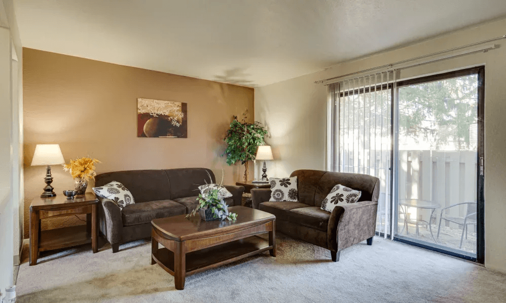A living room with a couch, a coffee table, and a lamp.