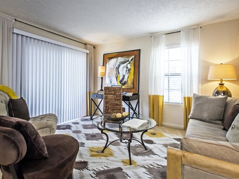 A living room with a brown chair and a painting on the wall.