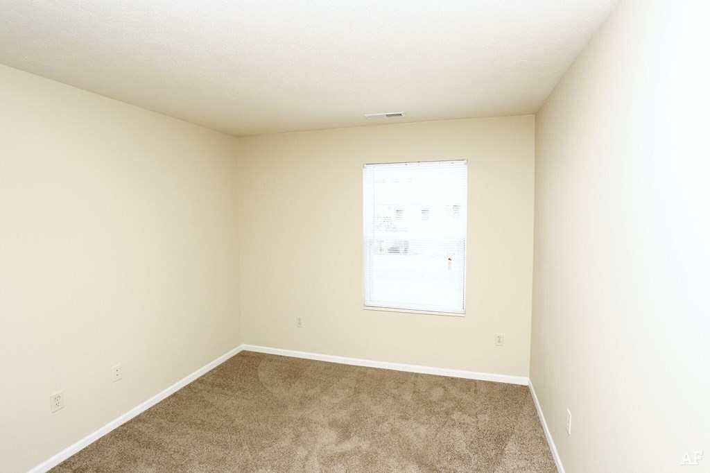 a bedroom with beige walls and carpet