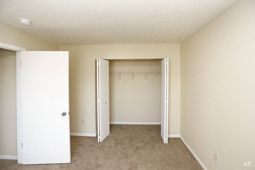 a bedroom with a closet and a door open