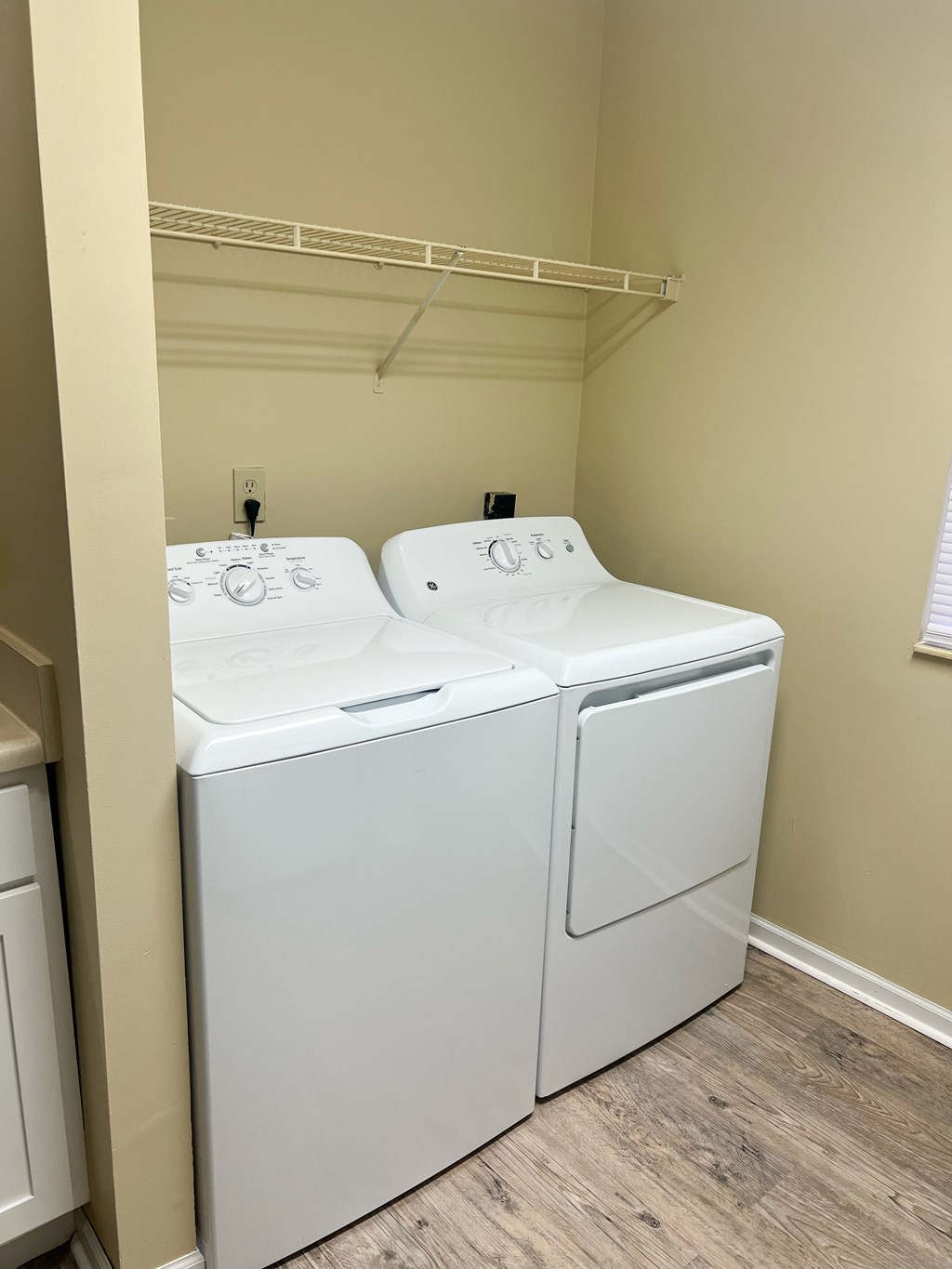A white dryer and washer in a small laundry room.