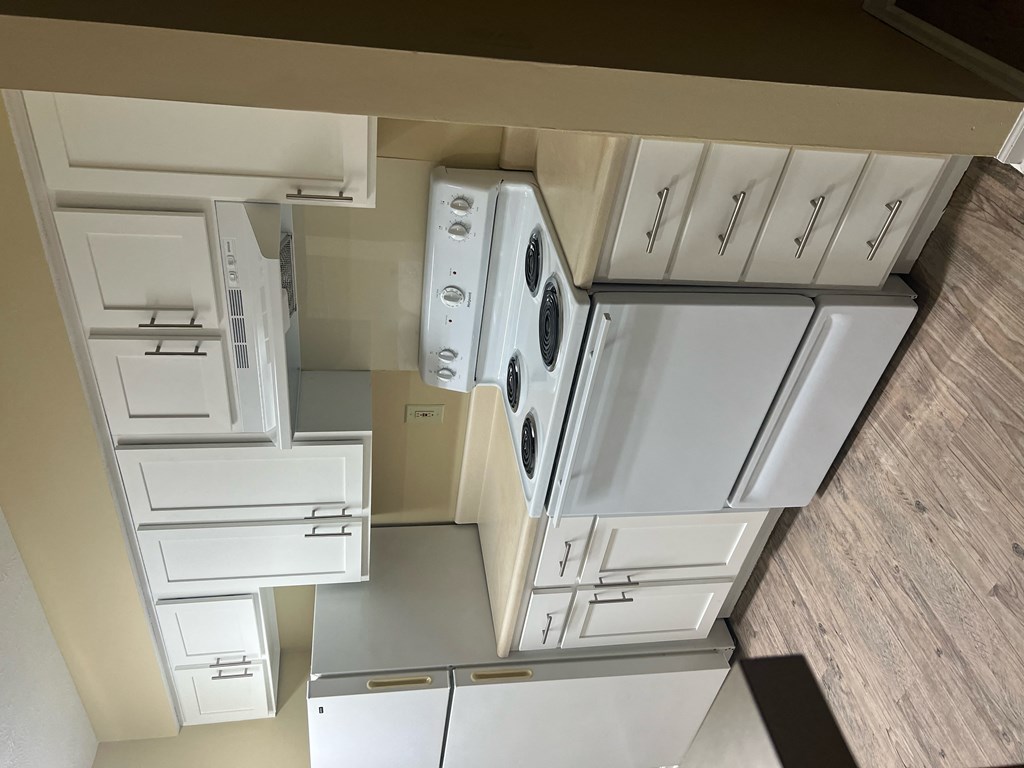 an overhead view of a kitchen with white cabinets and appliances