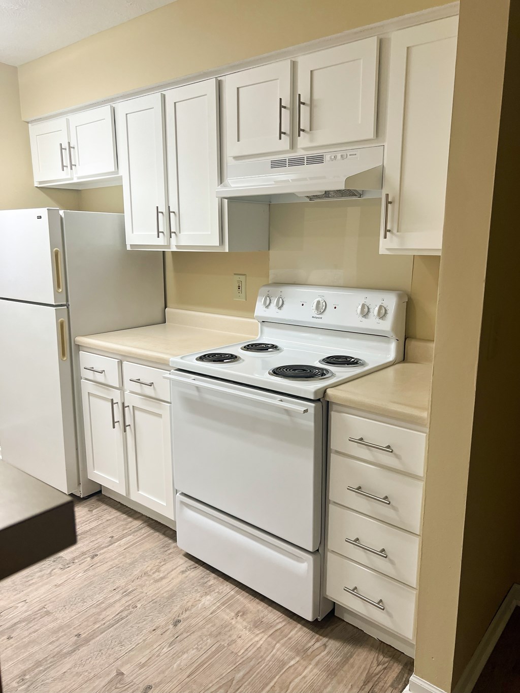 A white stove and refrigerator in a kitchen.