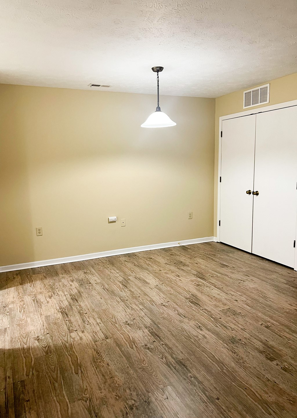 A room with a wooden floor and a white door.
