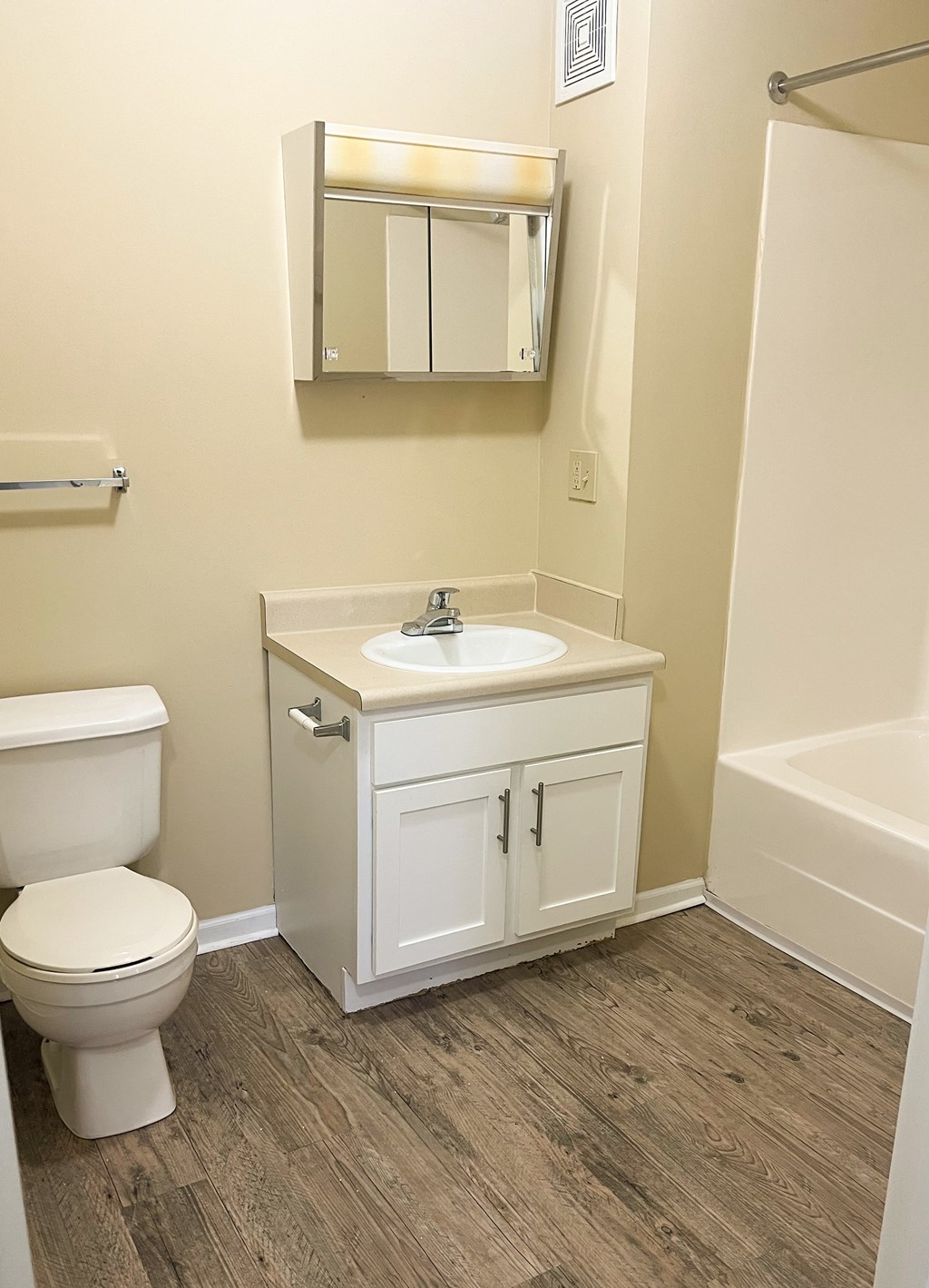 A white toilet sits next to a sink in a small bathroom.