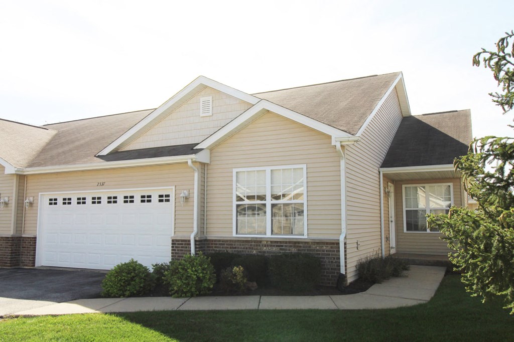 a yellow house with a white garage door