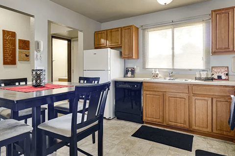 A kitchen with a table and chairs.