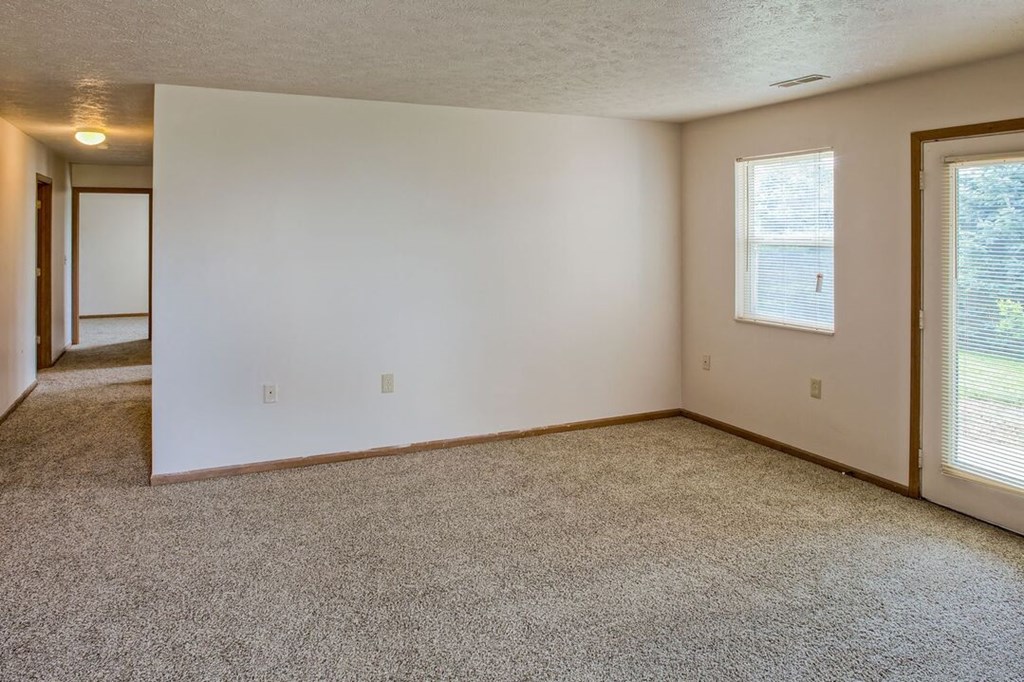 an empty room with a door and a window