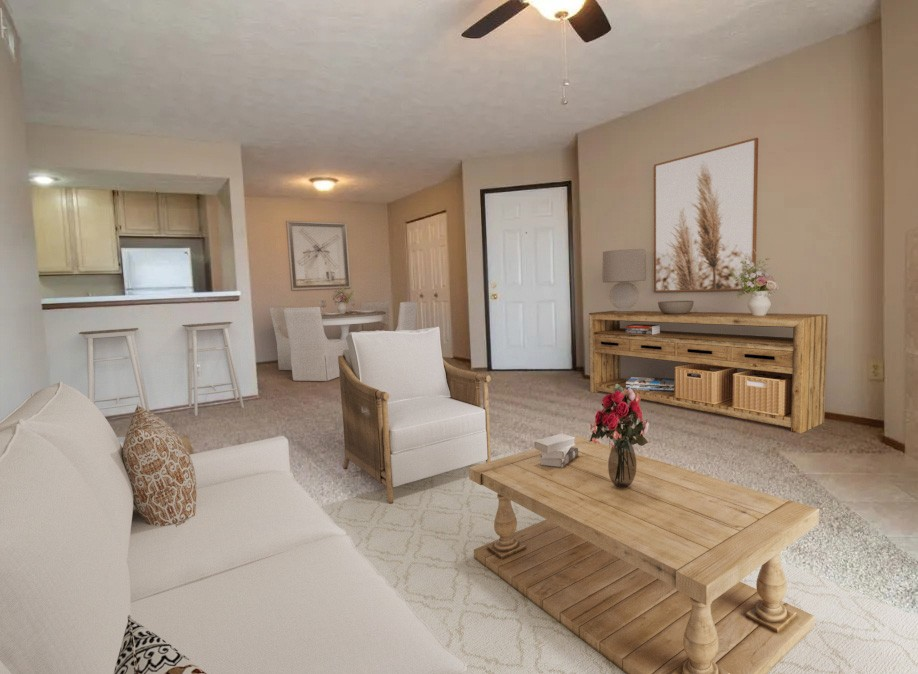 A living room with a white couch, a wooden coffee table, and a ceiling fan.