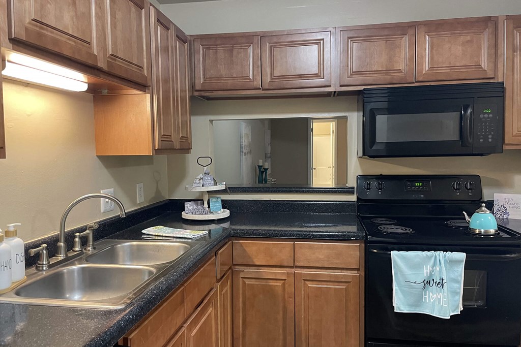 a kitchen with black appliances and wooden cabinets