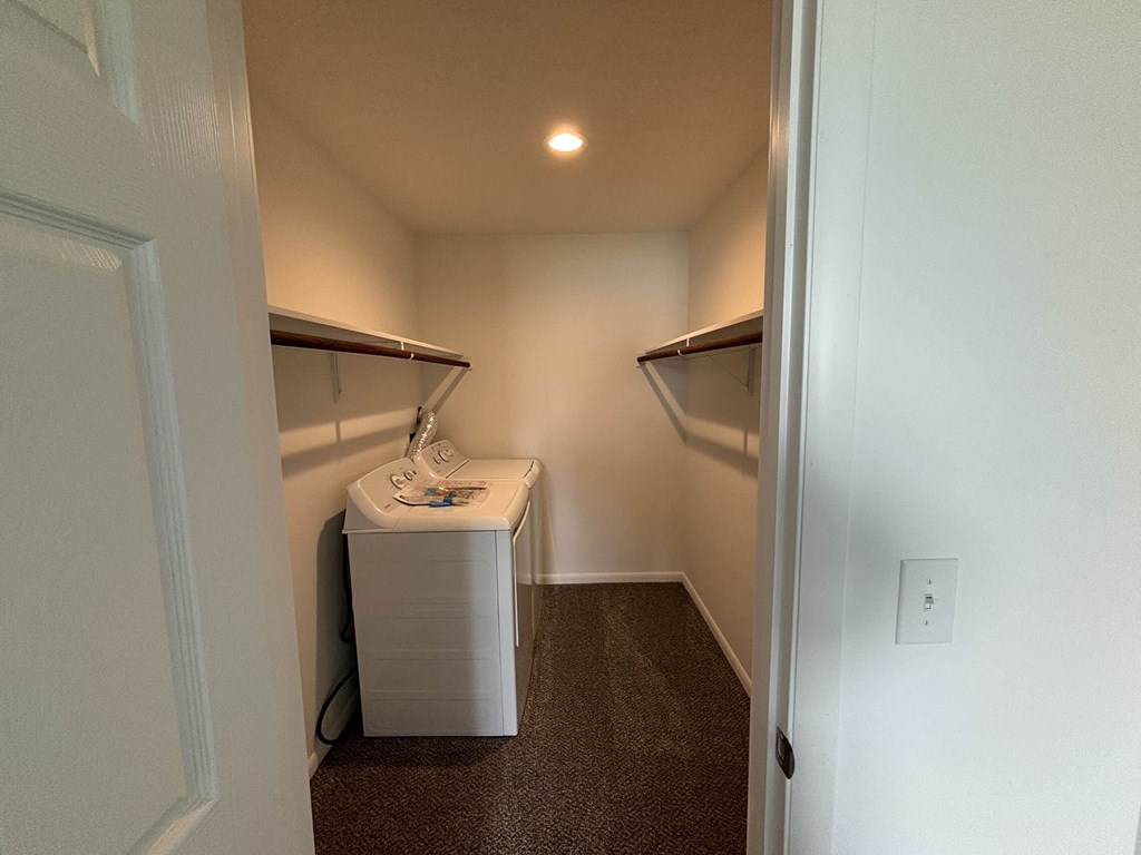 a walk in closet with a sink and a dryer
