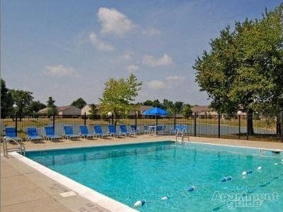a swimming pool with blue chairs around it