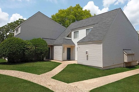 a white house with a gray roof and a lawn