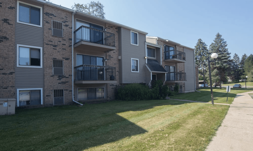 an apartment building with balconies and a lawn