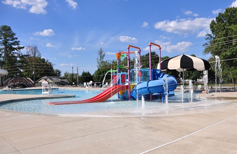 a childrens pool with a water playground and slides