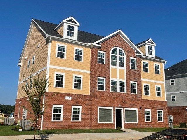 a large apartment building with red brick and yellow siding