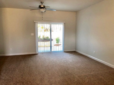 an empty living room with a sliding glass door