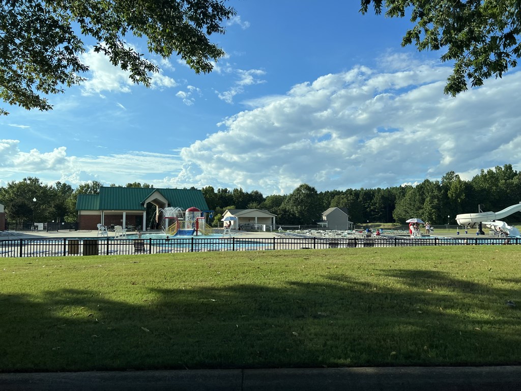 a view of a park with a pool and a building with a plane in the