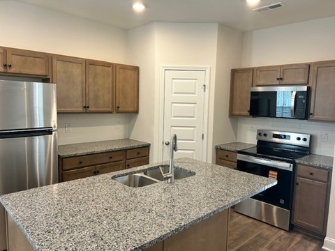 A kitchen with granite countertops and stainless steel appliances.