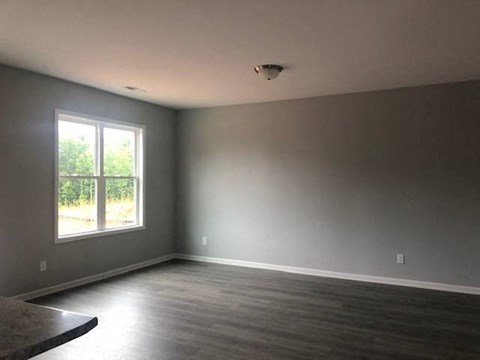 an empty living room with a window and