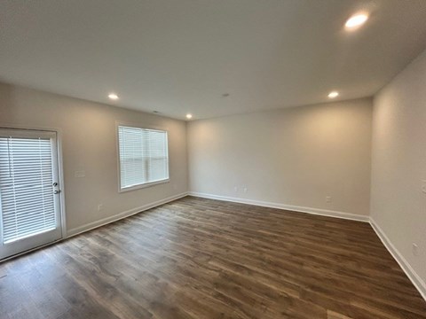 A room with wooden flooring and white walls.
