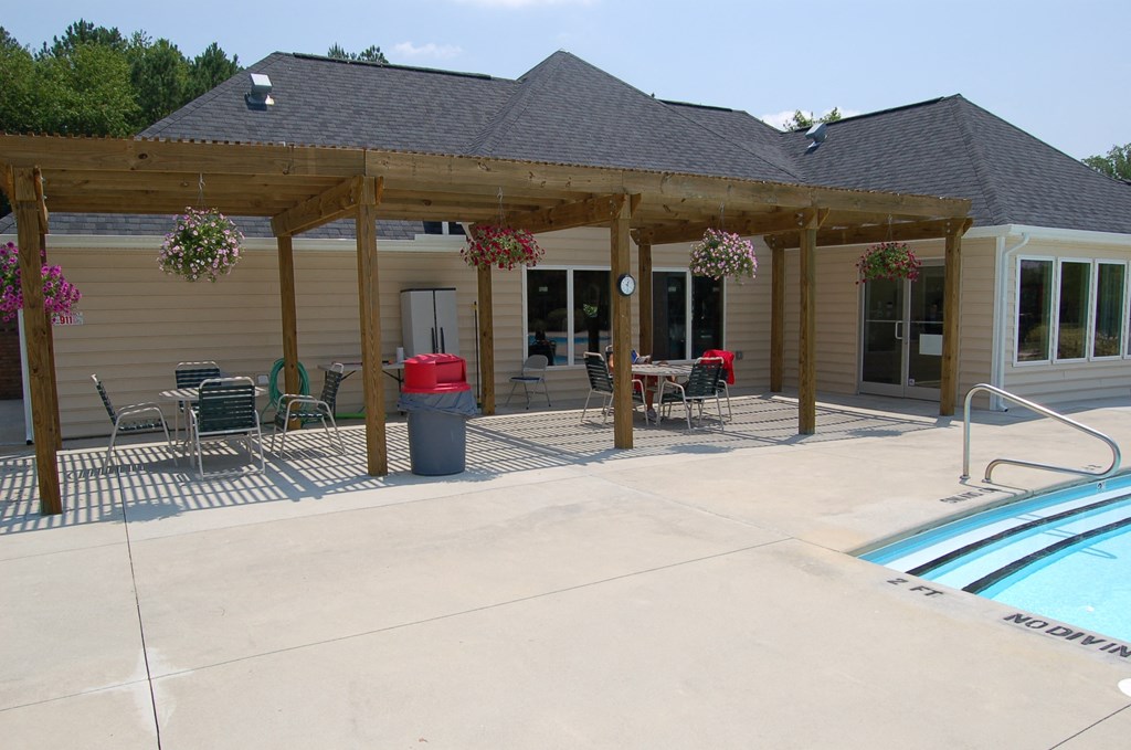 a covered patio with a pool in front of a house