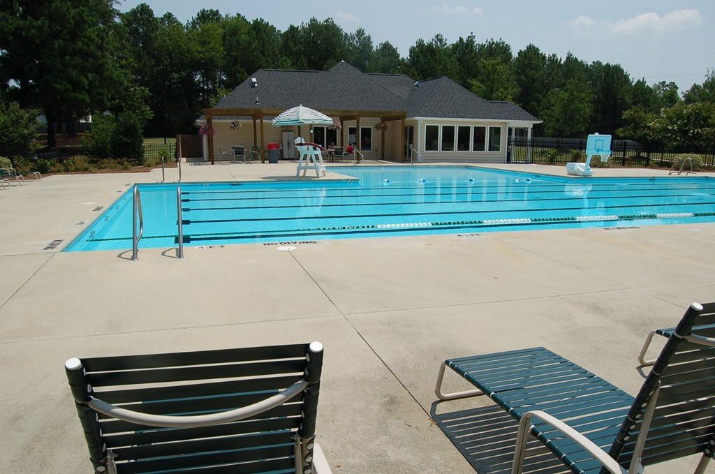 a swimming pool with a pool house in the background