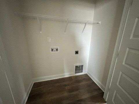 A room with a white wall and a small ventilation pipe.