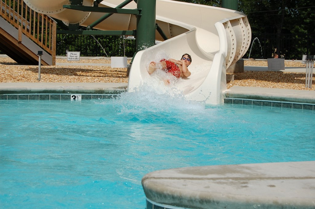a man on a slide in a swimming pool
