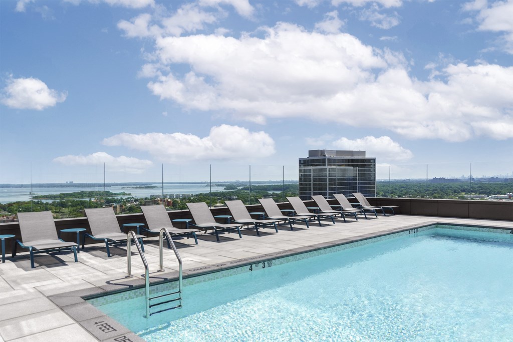 a pool with a row of lounge chairs on top of a building