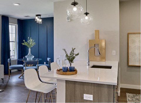 a kitchen with a sink and a table with chairs