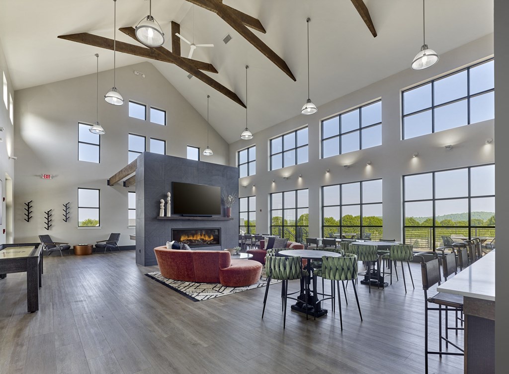 a large living room with a fireplace and tables and chairs