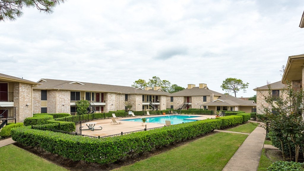 the view of a swimming pool with apartments in the background