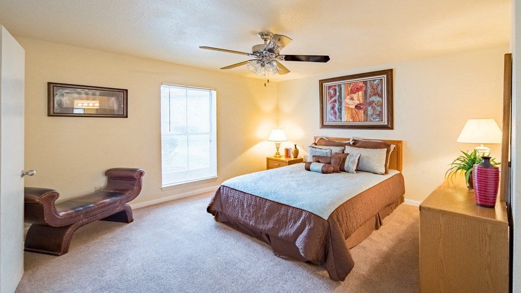 a bedroom with a bed and a ceiling fan