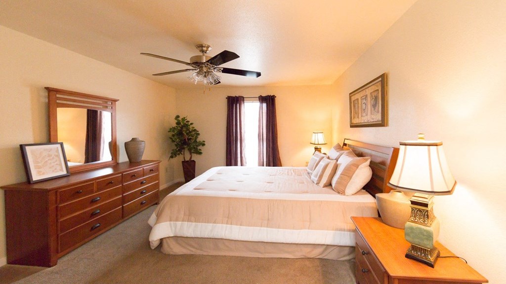a bedroom with a large bed and a ceiling fan
