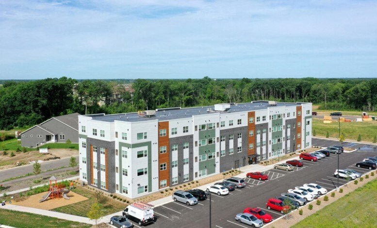 an aerial view of an apartment building with a parking lot