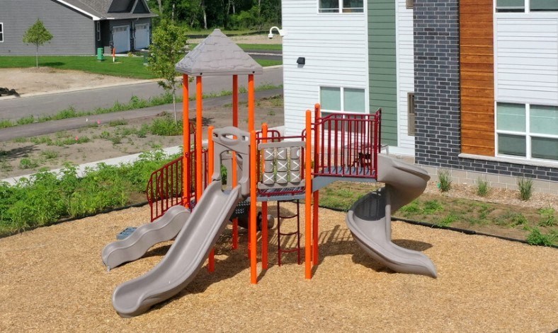 a playground with two slides and a swing set