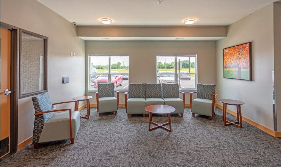 a waiting room at a hospital with chairs and tables