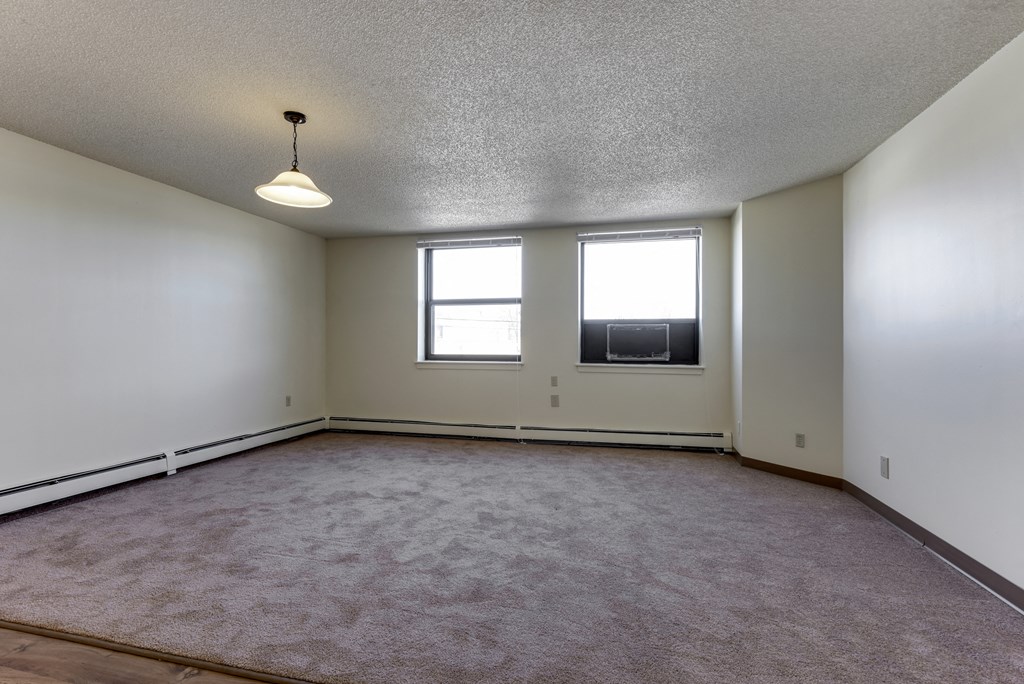 the living room of an empty house with two windows