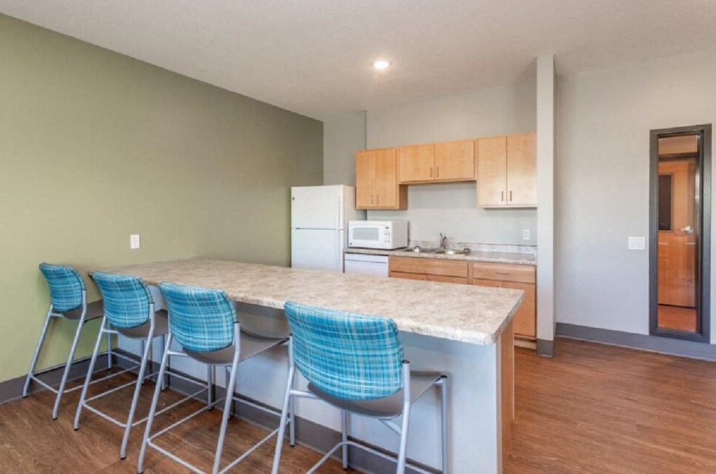 a kitchen with a marble counter top and three bar stools