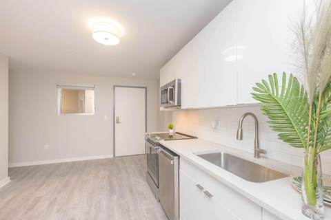 A kitchen with white cabinets and a sink.
