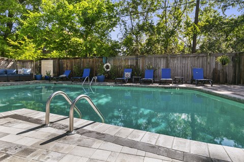 A pool with a metal ladder and a tiled edge.