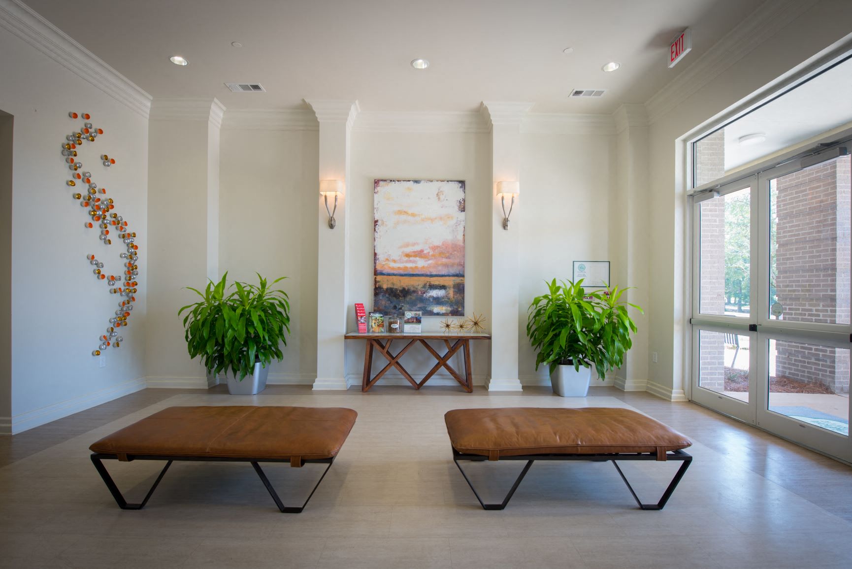 a lobby with two benches and a painting on the wall