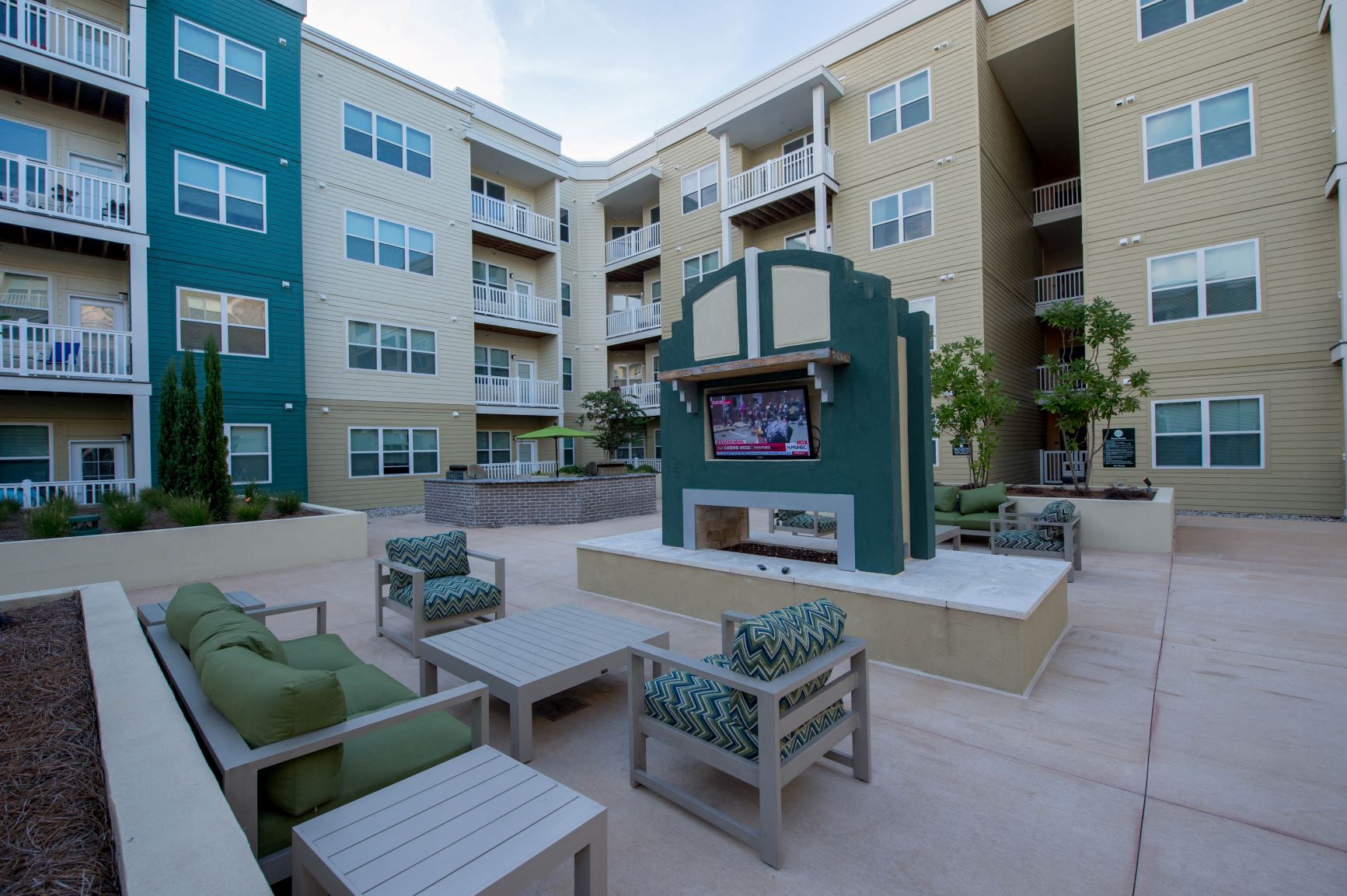 an outdoor seating area with a tv in front of an apartment building
